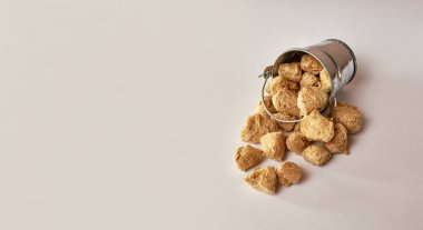 Beyaz arka planda küçük bir kovada desenli soya unu parçaları..