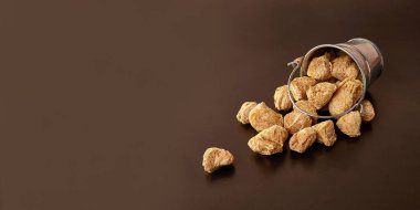 Kahverengi arka planda küçük bir kovada desenli soya unu parçaları..