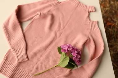 Beyaz çiçekli turuncu süveter.