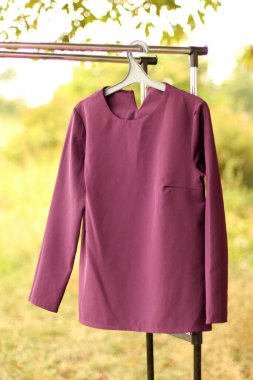 Mor gömlek askıda asılı..