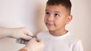 Küçük bir çocuğa boğaz pastili verilir..