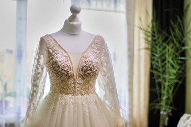 Güzel bir gelinlik odadaki bir mankene asılıyor. Düğün hazırlığı ve idaresi..