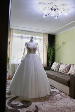 Güzel bir gelinlik odadaki bir mankene asılıyor. Düğün hazırlığı ve idaresi..