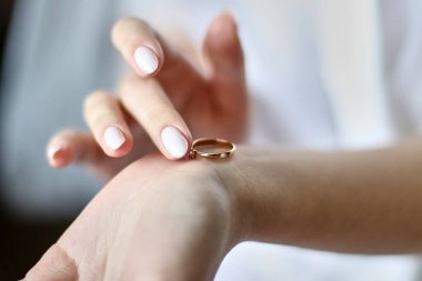 Gelin, düğün hazırlıkları sırasında elinde bir alyans tutuyor. Tatilin hazırlanması ve alıkonması.