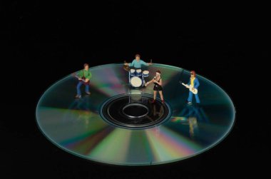 Siyah zemin üzerinde duran minyatür rock grubu