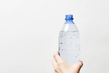 Birisi bir şişe köpüklü su tutuyor