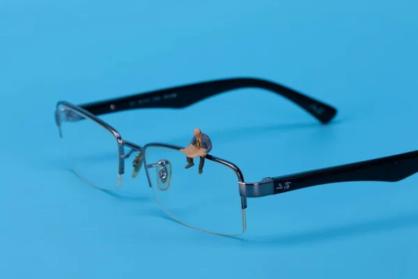 Minyatür Adam Oturuyor Gözlük Takıyor — Stok fotoğraf