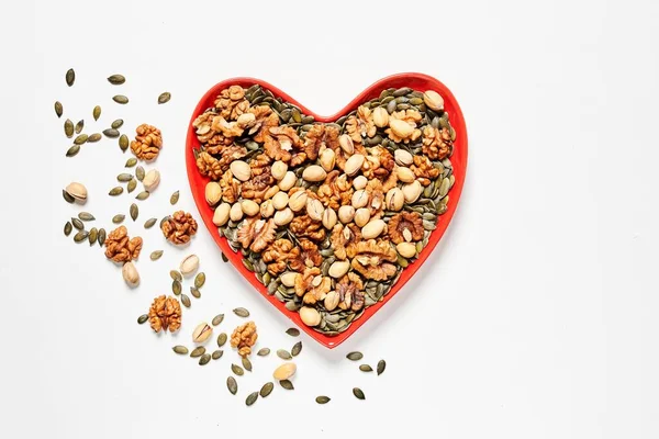 Kalp şeklinde bir tabak dolusu fındık.