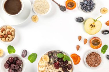 Kahve, yulaf ezmesi, meyve, fındık ve tohumla çerçevelenmiş. 