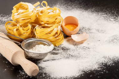 Koyu arkaplanda İtalyan yemekleri için Fettuccine makarna malzemeleri
