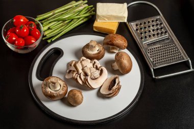 Koyu bir zemin üzerinde taze sebzeler ve mantarlar. 