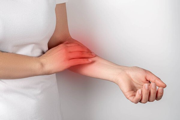 Pain in the arm, a woman touches a sore arm