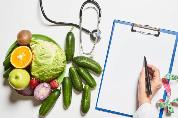 A dietician writing healthy dieting prescriptions on the paper