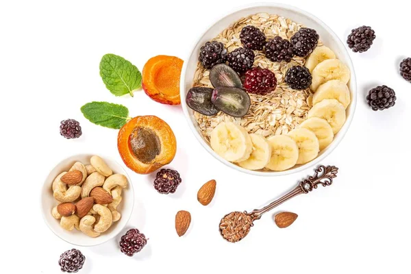 Beyaz bir sırt üzerinde muz, üzüm ve böğürtlen ile yulaf ezmesi