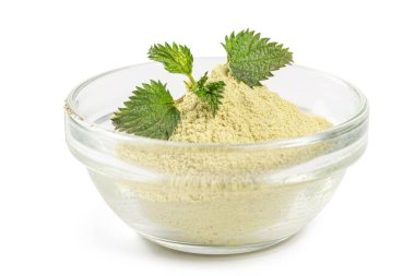 Isırgan otu tozu ve taze ısırgan otlarıyla dolu bir kase.