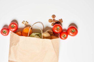 Çeşitli organik sebzeler ve meyvelerle dolu bir kese kağıdı.