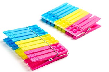 Pembe, sarı ve mavi plastik mandallar.