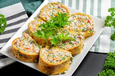 Dilimlenmiş peynirli omlet, otlar ve yengeç çubuklarıyla birlikte.