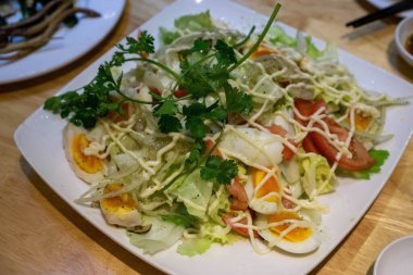 Haşlanmış yumurta, domates, soğan ve salata ile karışık salata.