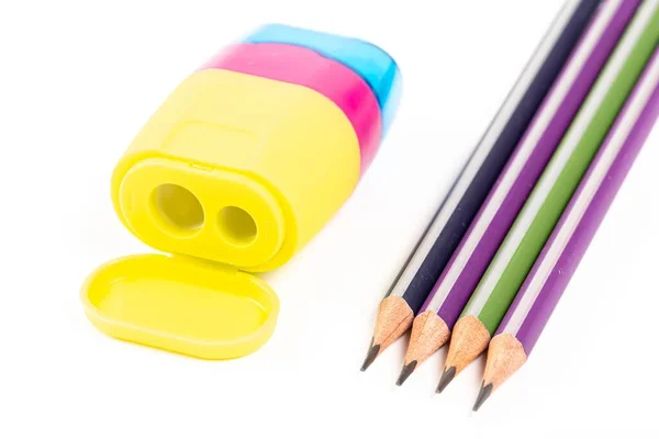 Four pencils and a multi-colored sharpener