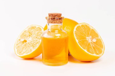 Bottle of essential oil from lemon and fresh ripe lemons on whit