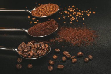 Üç kaşık kahve, kahve çekirdekleri ve zenciyle.