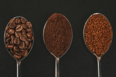 Kahve çekirdekleri, öğütülmüş ve hazır kahve kaşıkları, en üstte. 