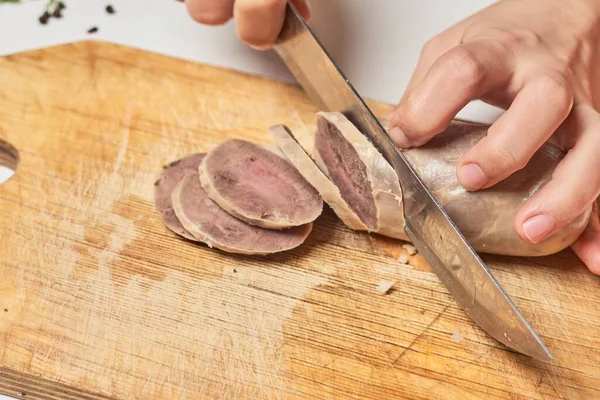 Kadın at eti kesiyor. Şarküteride şarküteri sosisi var.