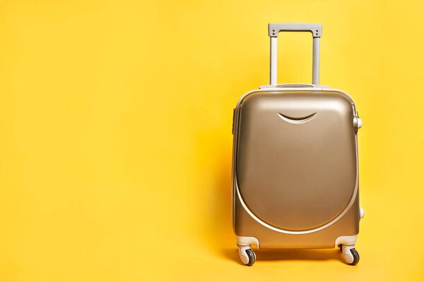 Travel suitcase on bright yellow background