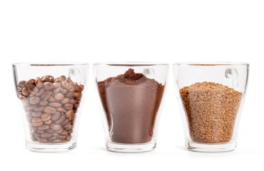 Kahve taneleri, öğütülmüş kahve çekirdekleri beyaz bardaklarda. 