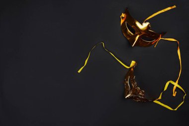Golden Mardi Gras masks on dark background