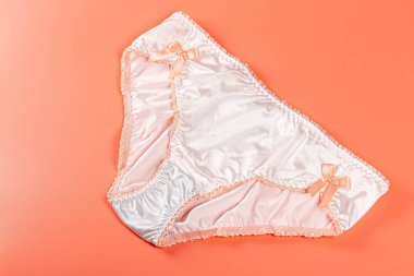 Şeftali arka planda ipek beyaz kadın külotu