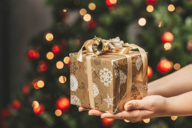 Noel tebrikleri bir kızın ellerinde bir hediyeyle