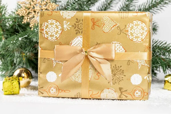 Close Gouden Kerstcadeau Met Takken Van Een Kerstboom — Stockfoto