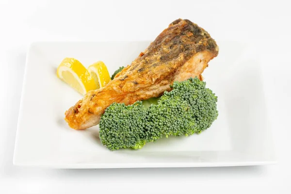 Fried fish with fresh broccoli and lemon