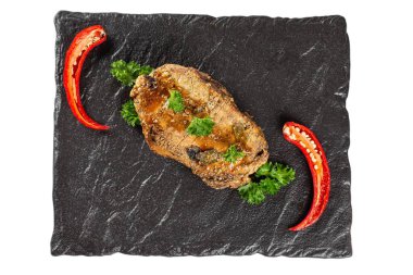 Üst manzara, siyah bir tepside pişmiş et.