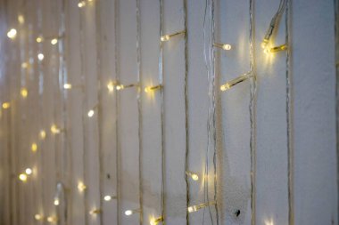 Bokeh 'in Kafe' deki Beyaz Duvar 'da asılı duran tel ışıkların fotoğrafı.