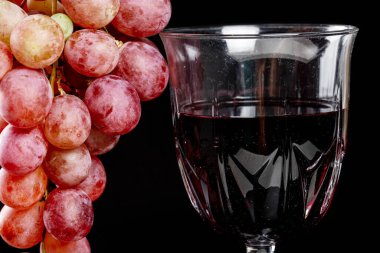 Yakın plan, bardakta kırmızı şarap ve taze üzüm.