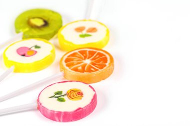 Beyaz arkaplanda çeşitli renkte lolipoplar, yakın plan