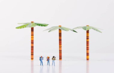 Beyaz arka planda ağaçlı minyatür gezginler