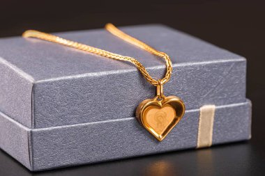 Mor hediye kutusunda altın zincir ve kolye.