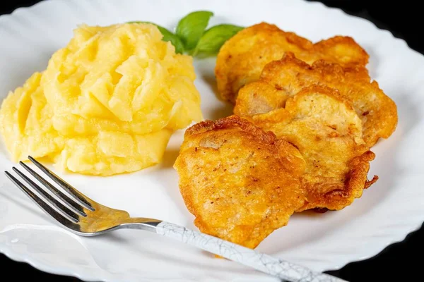 Yakın plan, patates püresi ve kızarmış balık parçaları.