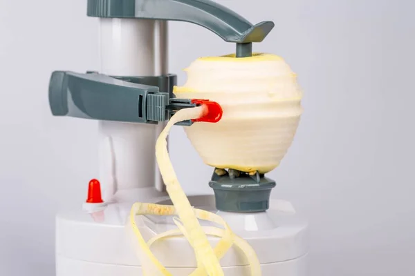 Peeling an apple in an electric peeler