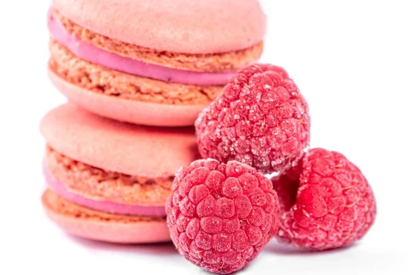 Close-up, pink macaroons with raspberries on white