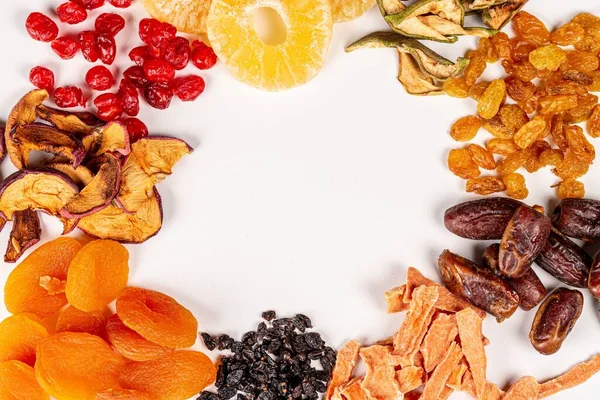 Beyaz üzerine farklı kurumuş meyve çerçevesi ve boş alan