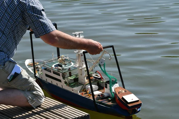 scale model of remote-controlled boats on a pond