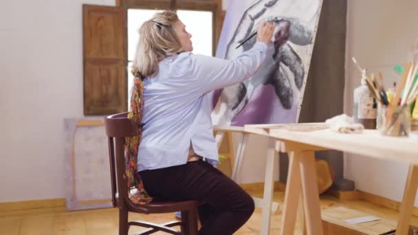 艺术家成熟的女人把业余时间花在自己的工作室里学习绘画技巧 — 图库视频影像
