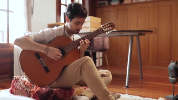 Adulto Joven Toca Guitarra Dormitorio Una Manera Relajada Casi Meditativa — Vídeo de stock