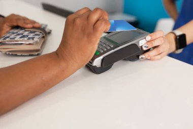 Siyahi bir ırk hastasının elini kapatırken dişçi kliniğinde alınan iyi hizmet için veri bankasından para ödüyorlar.