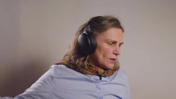一个成熟女人在业余时间用耳机听音乐的肖像 — 图库视频影像
